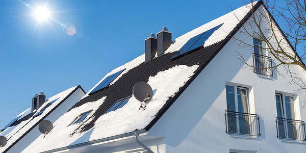 Einfamilienhaus mit Schnee bei blauem Himmel