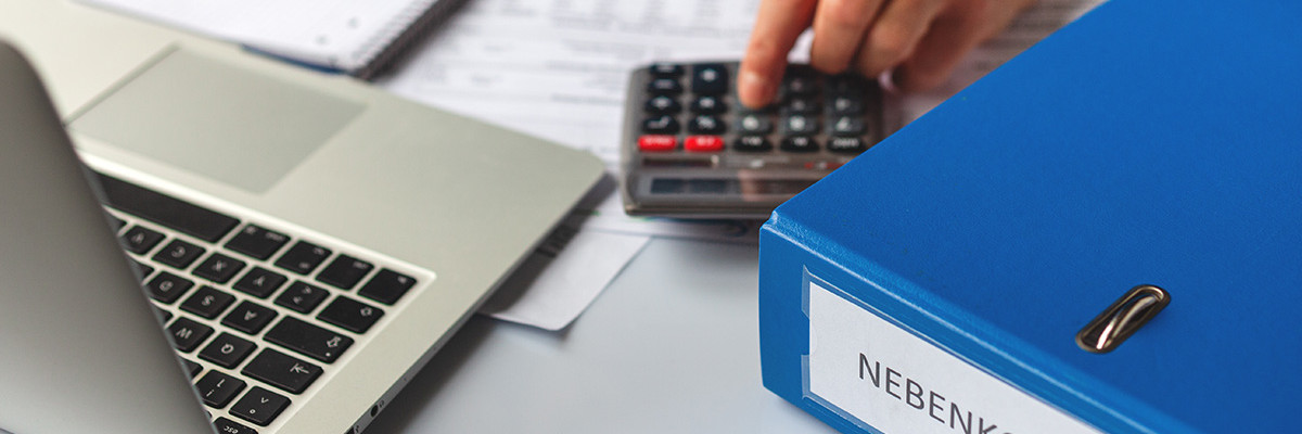 Mann tippt auf Taschenrechner neben Ordner mit Nebenkosten