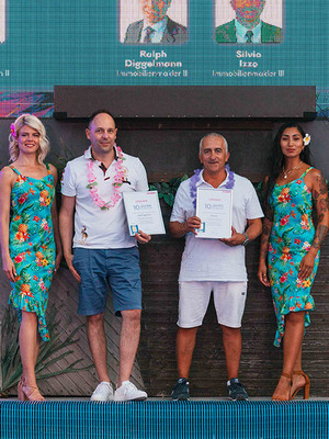 Männer halten Urkunde auf Foto mit Hostessen im Hawaii Kleid