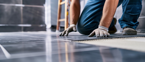 Mann verlegt Fliesen in Wohnung