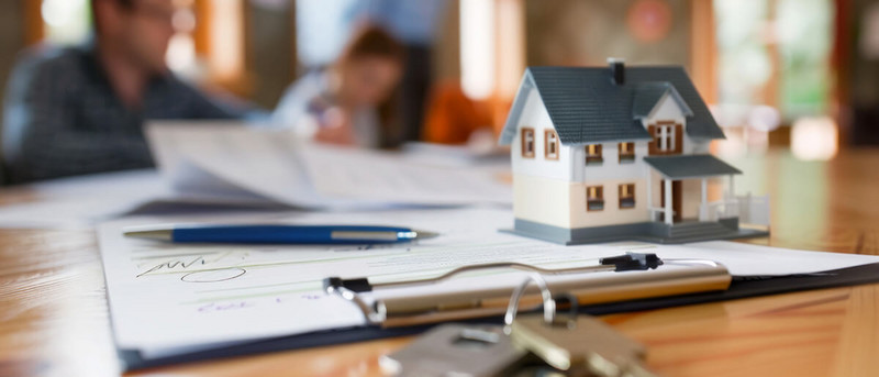 Modellhaus auf Tisch mit Dokumenten