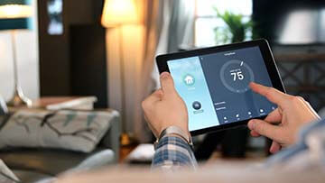 Im Wohnzimmer einer Eigentumswohnung mit Blick auf ein Smart Home Tablet