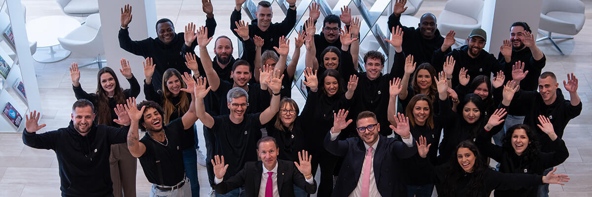Mehrere Mitarbeitenden strecken lachend die Hände in die Luft