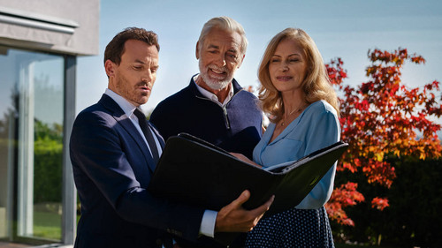 Makler bespricht etwas mit einem Kundenpaar