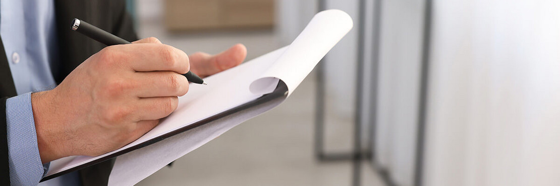 Mann schreibt auf Notitzblock