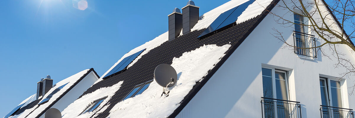 Einfamilienhaus mit Schnee bei blauem Himmel