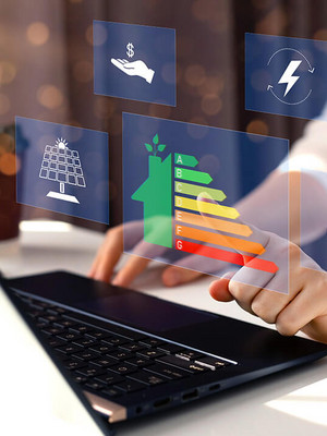 Mann tippt auf Laptop mit Energielabel