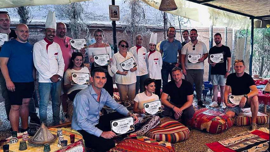 Gruppenbild von etwa 20 Personen, die ein Diplom in der Hand halten