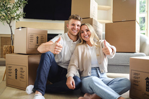 junges Paar sitzt vor Umzugskartons